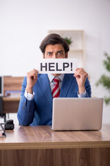 Young male employee sitting at workplace