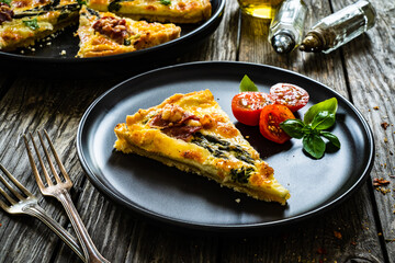 Tart with asparagus and serrano ham on wooden table
