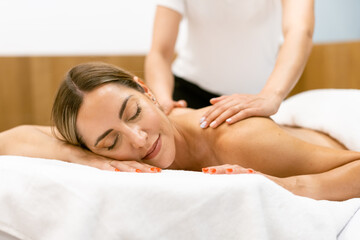 Fototapeta na wymiar Middle-aged woman having a back massage in a beauty salon.