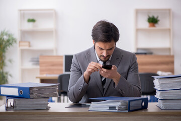 Young male employee unhappy with excessive work in the office