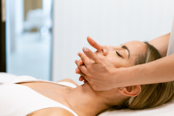 Obraz na płótnie Canvas Middle-aged woman having a head massage in a beauty salon.