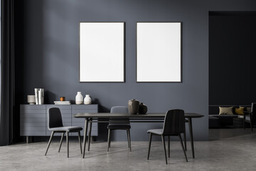 Two posters in the dark grey waiting room studio with table