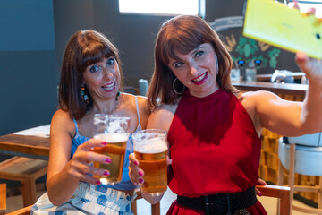 two female friends take a selfie while drinking beer