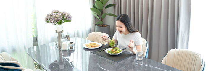 Cheerful young Asian woman happy eating healthy food