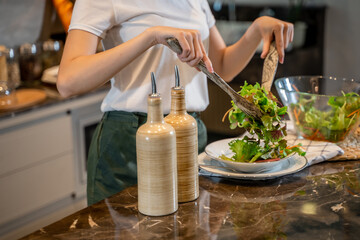 Happy young asian woman standing in kitchen and cooking healthy food. cook vegetable salad. Vegan Dieting Concept