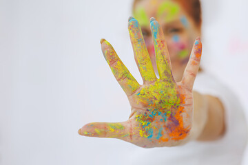 The red-haired girl is painted with multi-colored paints. Positive emotions of people, smiles. Holidays for the whole family. Laundry.