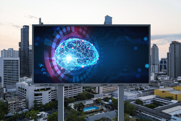 Brain hologram on billboard with Bangkok cityscape background at sunset. Street advertising poster. Front view. The largest science hub in Southeast Asia. Coding and high-tech science.