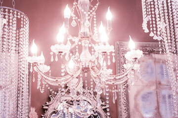 Crystal chandelier close-up. pink light. Selective focus.