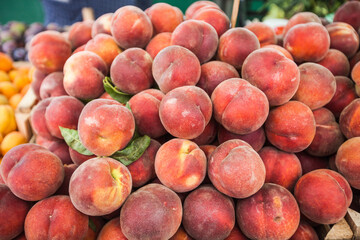 Heap of fresh ripe peaches at local farmers market