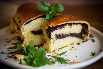 roll with poppy seeds inside on a wooden table.