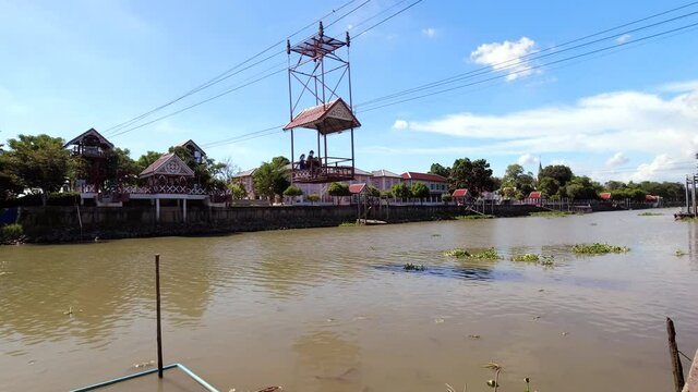People in a cable car crossing the Chao Phraya River towards Wat Niwet Thammaprawat 