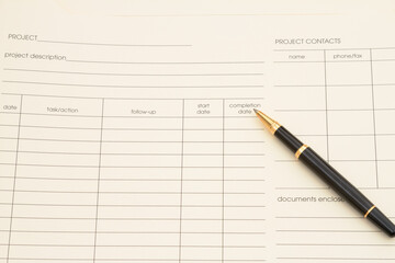 Manila project plan folder with a pen