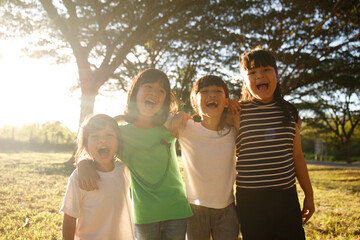 Group of kindergarten kids friends arm around and smiling fun With sunset