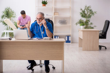 Fototapeta premium Young male patient visiting old male doctor