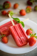 homemade strawberry ice cream on a stick made from fresh strawberries in a plate