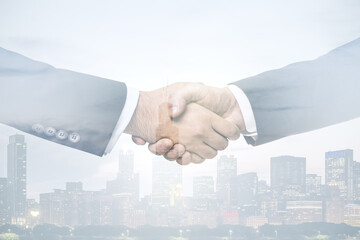 Multi exposure of handshake of two businessmen on city skyscrapers background, collaboration and teamwork concept