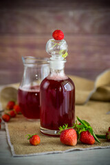 sweet cooked strawberry syrup in a glass decanter