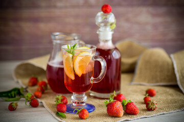 refreshing cool strawberry lemonade with lemon, ice and mint in a glass