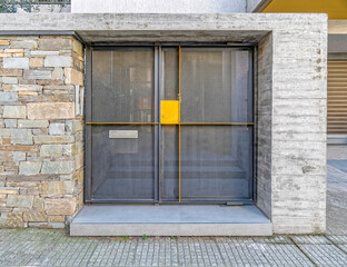 modern house front entrance metallic door by the sidewalk