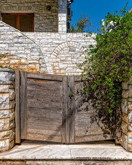 contemporary house stone fence and wooden entrance door