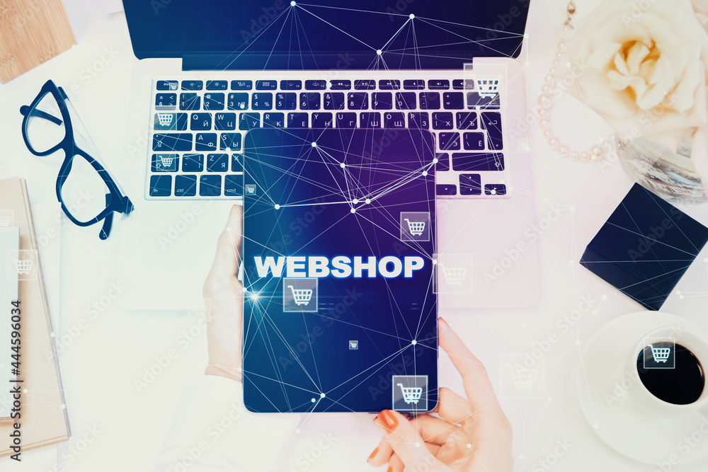 Poster close up of female hands using tablet with creative webshop inscription on screen. office desktop wi
