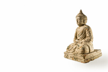 Ancient looking little Buddha figurine or statue in a sitting posture - isolated on white background for copy paste text.