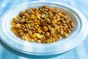 Assorted mix of nuts on a paper plate.