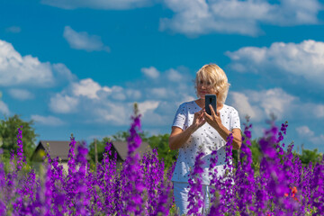 Outdoor portrait of a beautiful happy middle aged blonde woman in a field with flowers
