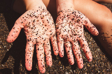 hands covered in pebbles 