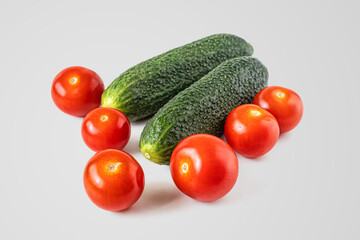 Ripe green cucumbers and small red cherry tomatoes