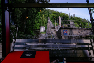 Red Funicular Train driving downhill from Harder Kulm, Top of Interlaken. Funicular drives tourists...