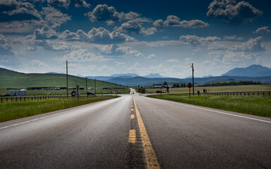 Fototapeta premium An intersection on ranch land along Highway 22 near the Livingstone mountain range and Alberta East slopes of the Canadian Rockies during the summer.