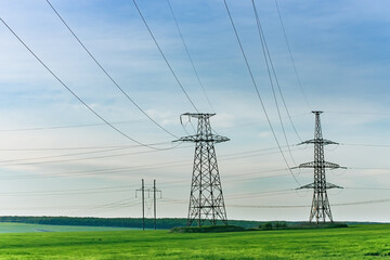 High voltage electric pylon and electrical wire at green field. Electricity pylon and High voltage grid tower with wire cable. Power and energy concept