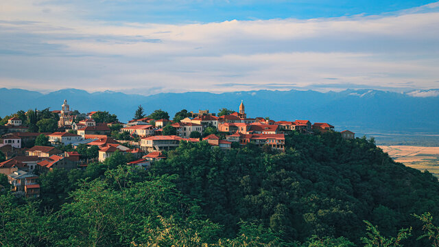 View of Sighnaghi in winery region of Georgia, Kakheti, during sunset in summer with Caucasus mountains in the background