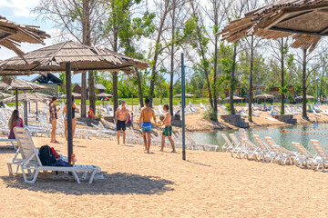 Young people are going to play volleyball on the sand. Beach activity