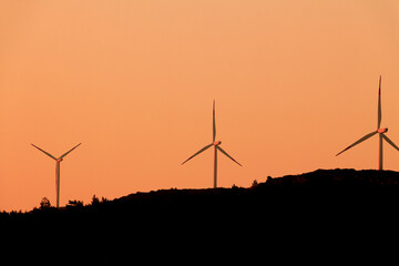 Wind turbines in the orange sky. wind power for clean energy.