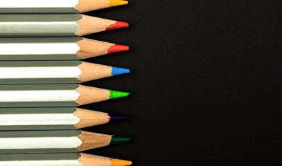 Obraz premium Wooden color pencils close-up. Border composition with black background. Top view and copy space photo