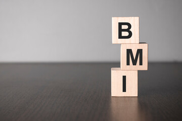 Businesswoman made word bmi with wood building blocks.