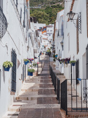 Narrow street with flowerpots, typical of Andalusian village in Mijas, Costa del Sol, Spain
