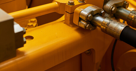 Close up view of hydraulic pipes of heavy industry machine. Low key.