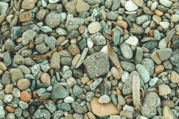 , small colored pebbles on the beach. Pebble background on the beach 