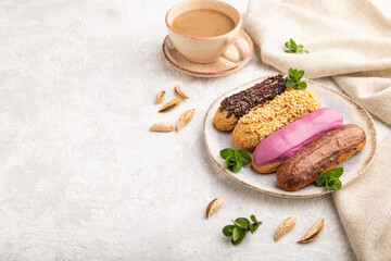 Set of eclair, traditional french dessert and cup of coffee on gray concrete background. side view, copy space.