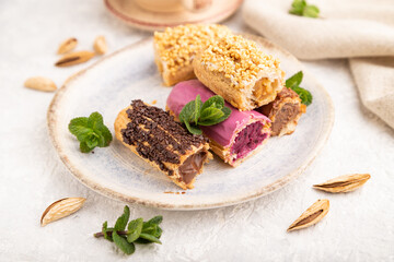 Set of eclair, traditional french dessert and cup of coffee on gray concrete background. side view, close up, selective focus.