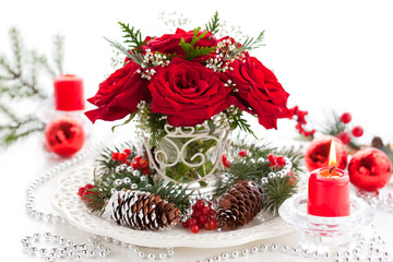 Christmas arrangement with red roses, pine cones and winter berries. Christmas table setting
