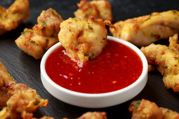 Chicken Pakora dish with sweet chilli sauce on rustic stone board