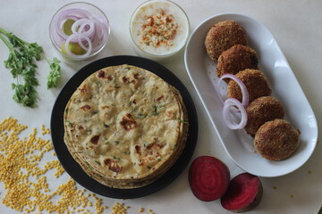 A high protein Indian flat bread with whole wheat and lentils. Popularly known as moong dal paratha in many parts of India. Served with vegetarian beetroot cutlets.