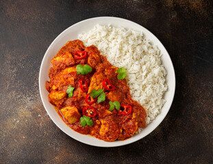 Spicy Chicken Pathia curry with basmati rice in a white plate. healthy food.