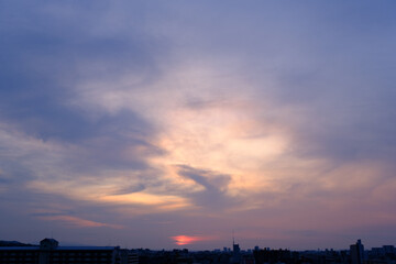 兵庫県神戸市東灘区の高層マンションの上層階からの夜明け。大阪生駒山から太陽が昇り、あたりはオレンジ色に染まり、ビル群がシルエットで浮かぶ