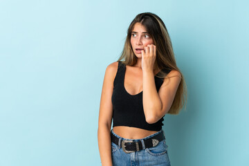 Young caucasian woman isolated on blue background is a little bit nervous