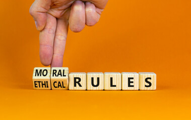 Ethical or moral rules symbol. Businessman turns wooden cubes and changes words 'ethical rules' to...